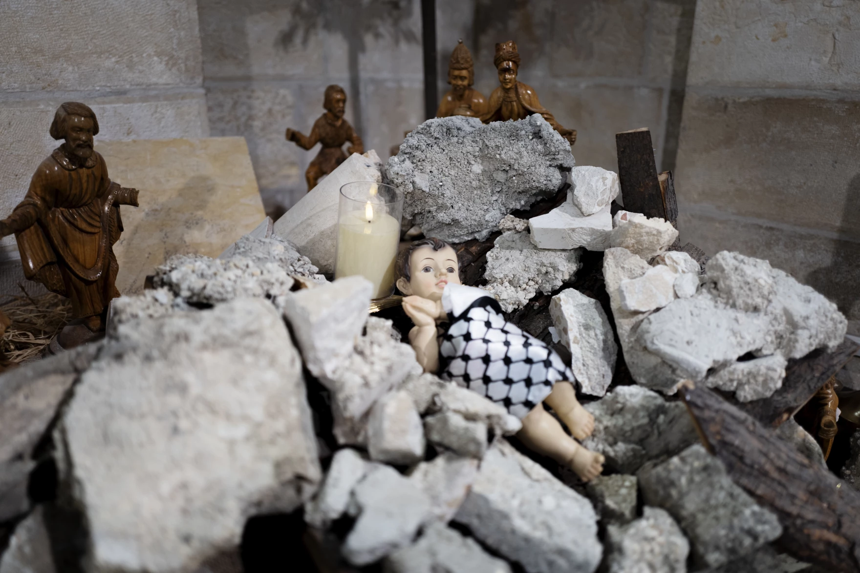 Nativity scene of Baby Jesus swaddled in a
keffiyeh, buried in rubble